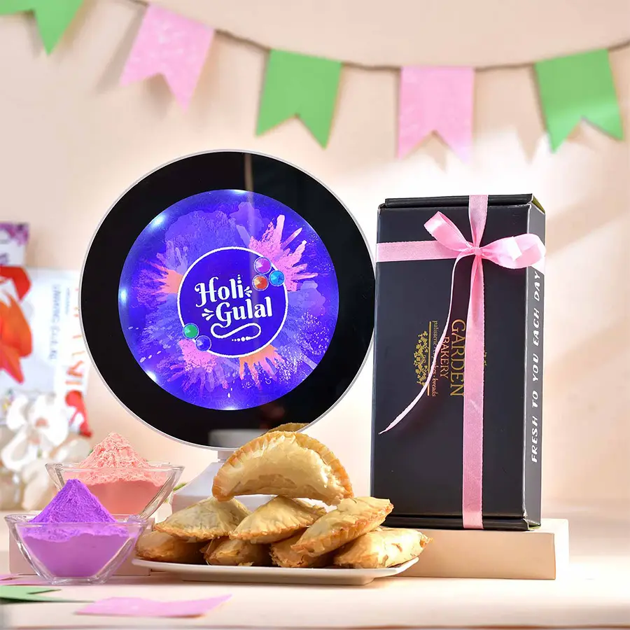 Enchanting Holi Ensemble Hamper featuring a Magic Mirror Lighting Frame, Baked Mewa Gujhiya, and vibrant Organic Gulals in a festive setting