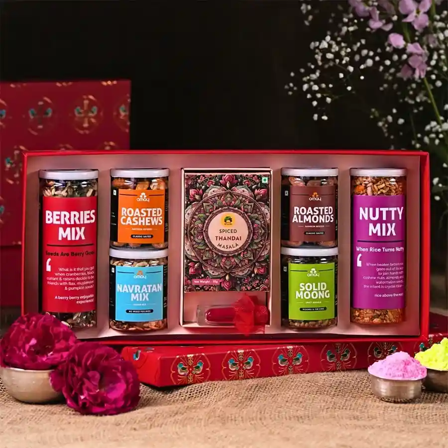 Holi Harmony Gift Box featuring a colorful assortment of nuts, dried fruits, spicy masalas, herbal gulal tube, Instant Thandai, and a festive greeting card in a gold-foiled box.
