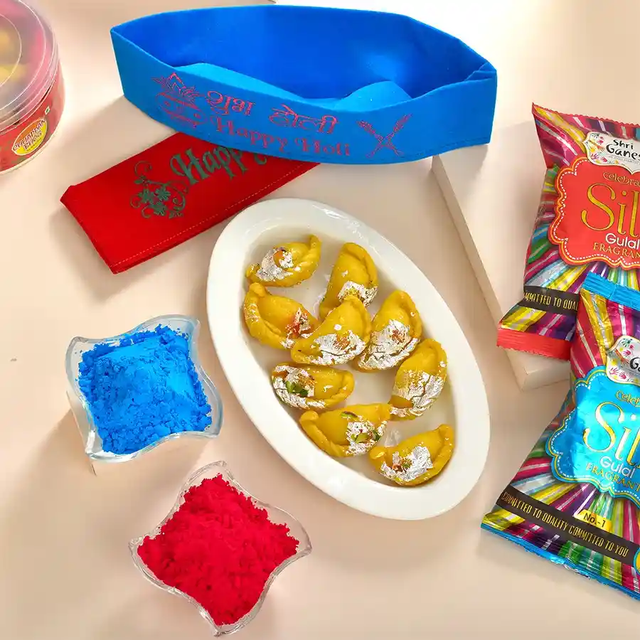 Divine Holi Treats N Gifts Set including Chhappan Bhog Kesariya Baby Gujiya, vibrant Happy Holi Caps, and Shri Ganesha Herbal Fragrant Gulal packs