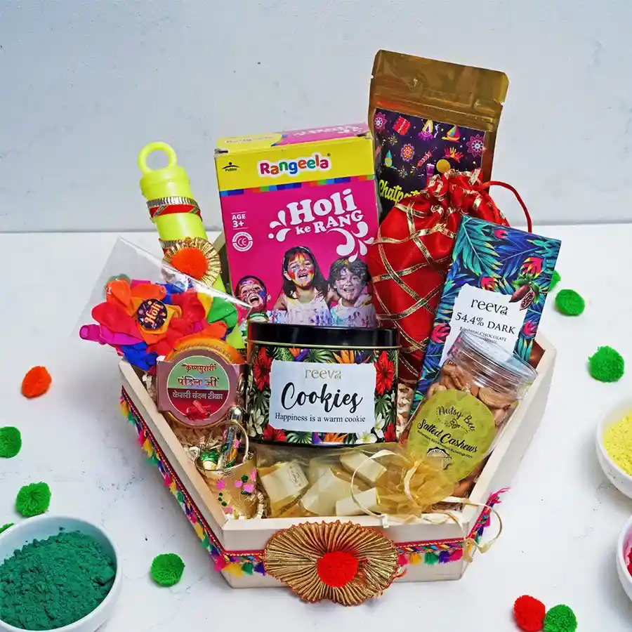 Impressive Holi Treats N Gifts Delight Set featuring dark chocolate, chatpata mix, assorted chocolates, strawberry crisp logs, Holi balloons, colorful powders, Kesari Chandan Tika, and a pichkari arranged in a festive presentation.