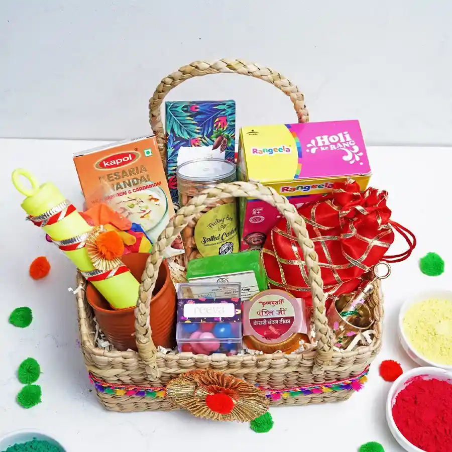 Holi Harmony Gift Basket featuring dark Belgian chocolate, salted cashews, colorful dragees, Kesaria Thandai, Kasari Chandan Tika, vibrant Holi colors, a pichkari, Khadi Aloe Vera soap, Strawberry Crisp Logs, and a Kullad cup