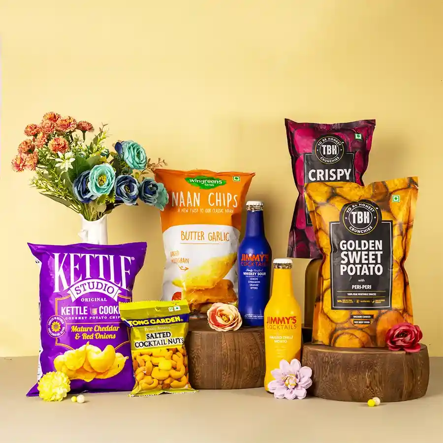 A beautifully arranged hamper filled with cocktail mixes, assorted crunchy snacks, and nuts, showcasing vibrant colors and appealing textures, perfect for celebration and enjoyment.