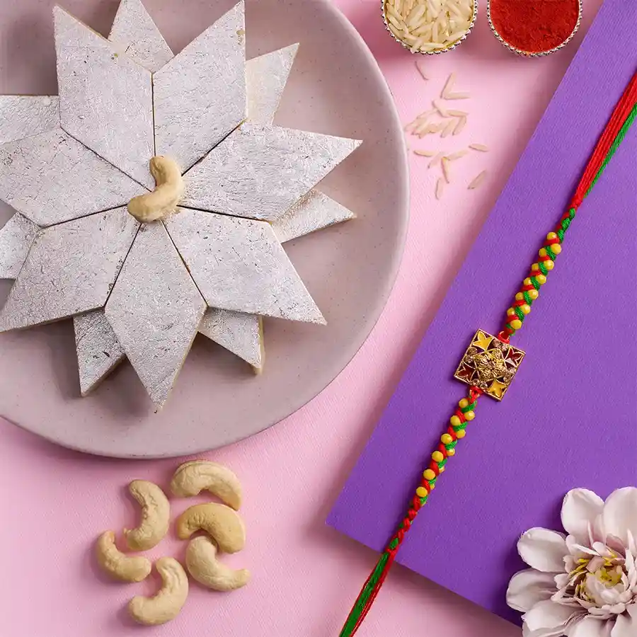 Designer Kundan Rakhi with Kaju Katli, Roli, Tika, Chawal, and message card on a festive background