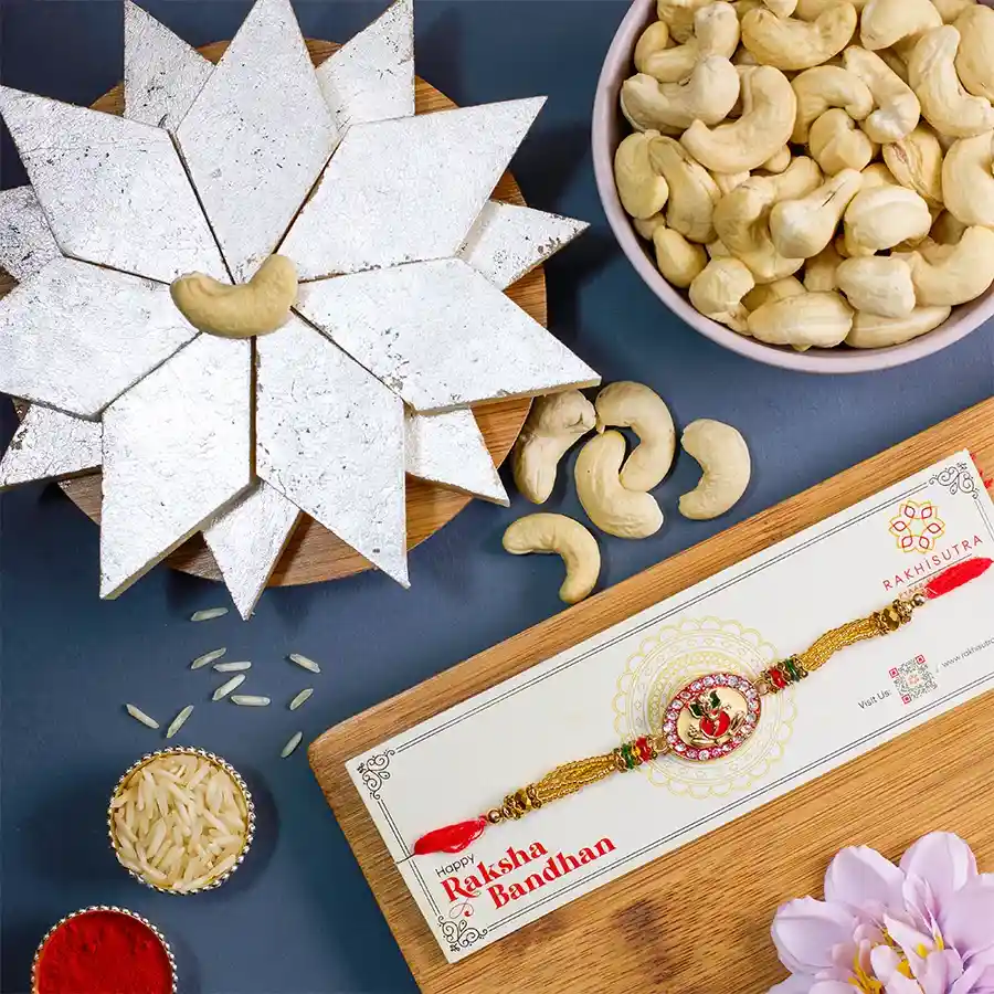 Fancy Ganesha Rakhi Combo with Kaju Katli, cashews, Roli, Tika, Chawal, and a message card