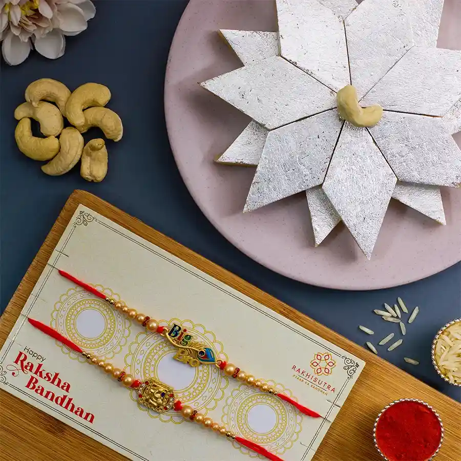 Sacred Rakhi N Katli Treat Set featuring Ganesha and Krishna Rakhis, 250g Kaju Katli, Roli, Tika, Chawal, and a personalized message card
