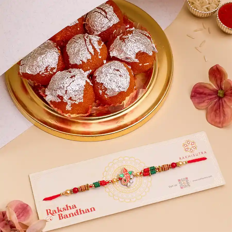 Ghee Laddu N Ganesha Rakhi Surprise bundle featuring Ganesha Rakhi, a box of 500g ghee laddus, and complimentary Roli, Tika, and Chawal with a message card.