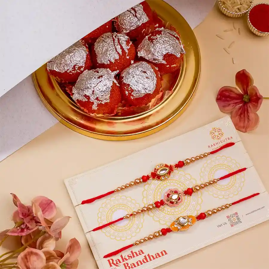 Elegant Kundan Rakhi and Sweet Treat Bundle featuring three Kundan Rakhis, 500g of Ghee Laddus, and complimentary Roli, Tika, and Chawal, with a free message card.