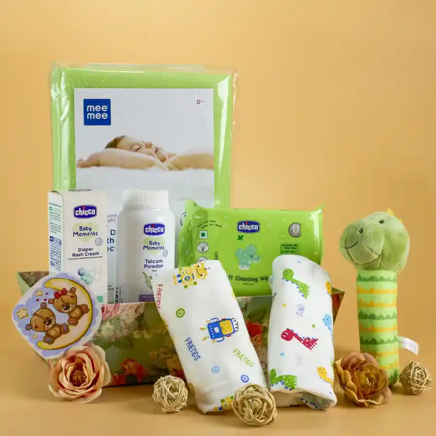 Baby Care N Comfort Essentials Gift Set arranged in a stylish reusable designer basket, featuring Mee Mee Dry Sheets, two Cotton Nappies, Chicco Talcum Powder, Diaper Rash Cream, soft wipes travel pack, and an adorable Plush Rattle.