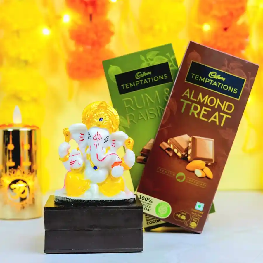 Graceful Mukut Ganesh idol with Cadbury Temptations chocolates in Rum N Raisins and Almond Treat flavors, elegantly packaged for gifting.