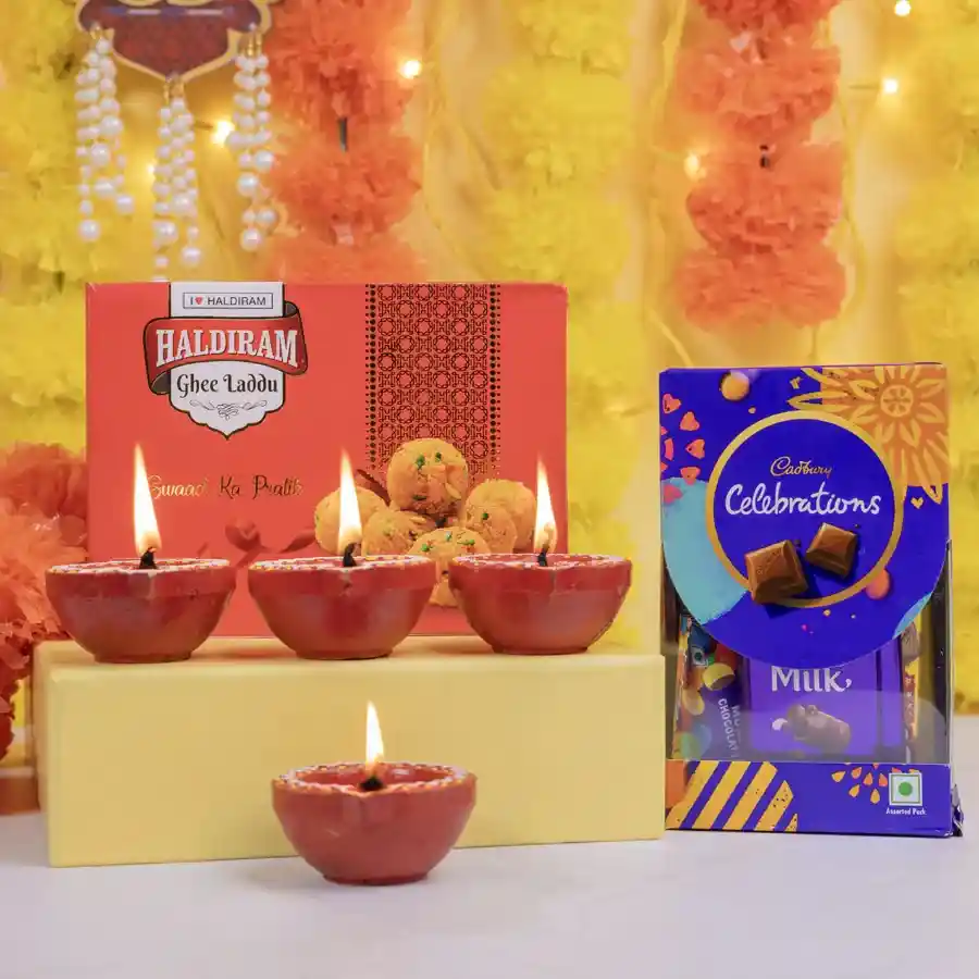 Sweet Delight N Celebration Chocolates Gift Set featuring Ghee Laddus, Cadbury Celebrations chocolates, and Mud Diyas arranged beautifully for a festive celebration.