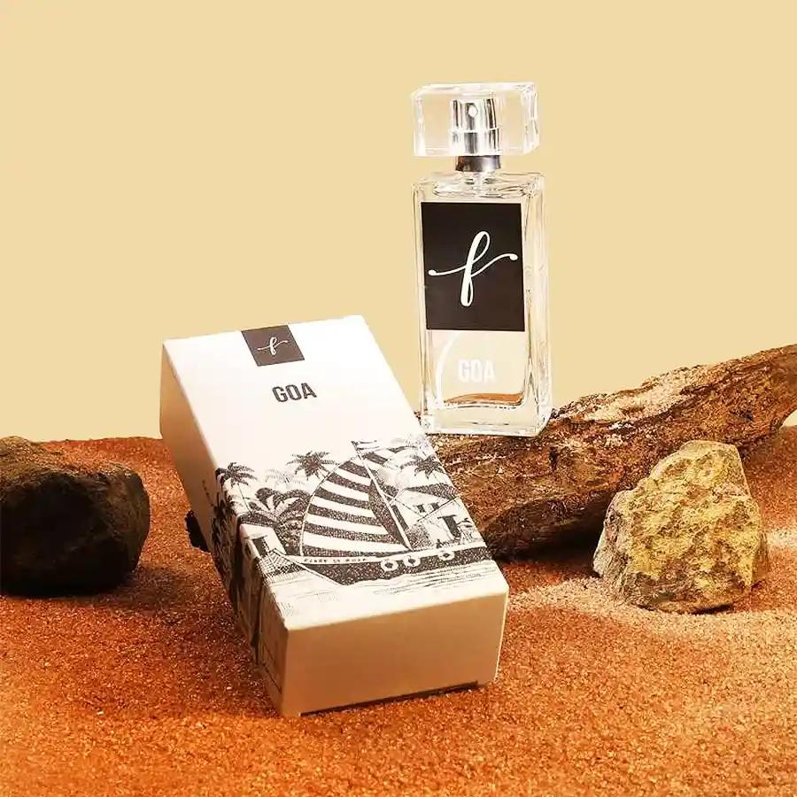 Goa Essence Fresh Coastal Escape perfume bottle with scenic beach background and Mario Miranda's sketch design on the box.