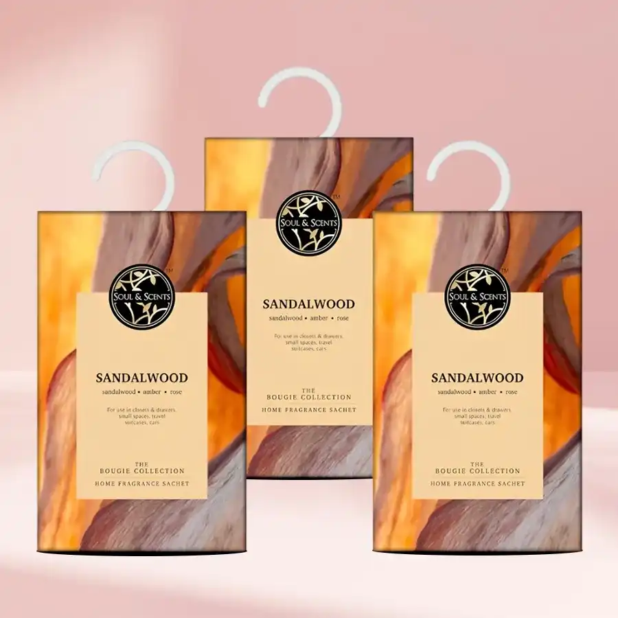 Sandalwood Essence Sachet Collection featuring three sachets with soothing sandalwood, earthy patchouli, and exotic ylang notes in a decorative setting.