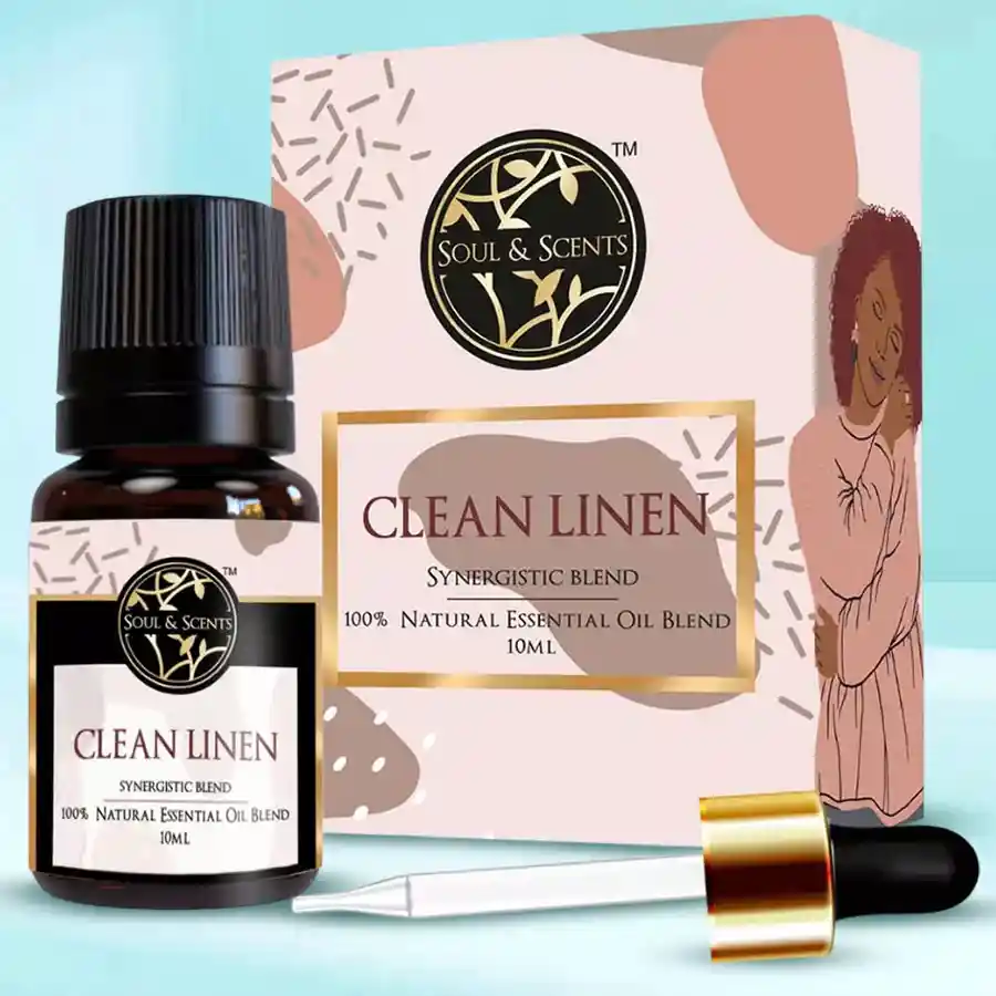 Bottles of Outstanding Clean Linen Essential Oil on a wooden surface with soft linen fabric in the background