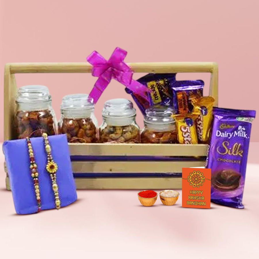 Classy Twin Stone Rakhi Gift Set with stone-studded Rakhis, flavored cashews jar, Cadbury Dairy Milk chocolates, wooden basket, personalized Rakhi card, and Roli Tilak and Chawal.