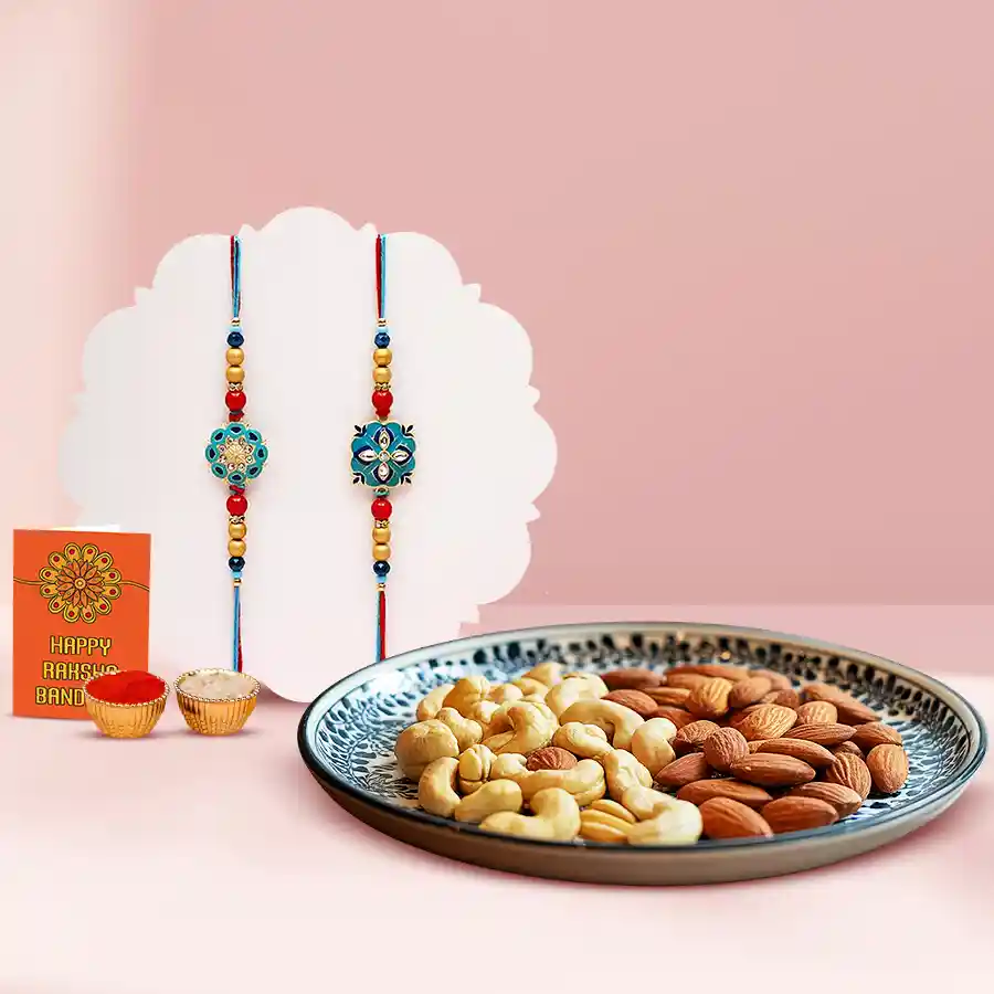 Traditional Twin Rakhi Set with Cashews and Almonds, featuring two elegant rakhis, a bowl of crunchy cashews, a bowl of premium almonds, a Roli Teeka, Chawal, and a personalized message card.