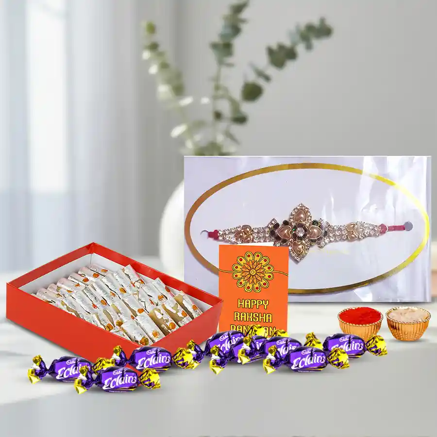 Trendy metal stone rakhi set with Haldiram sweets and Cadbury Eclairs, beautifully packaged with a card and traditional ingredients.