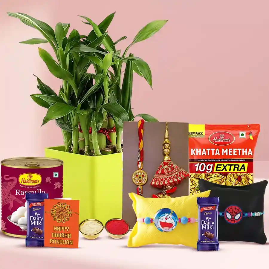 Family Rakhi set featuring a 2-tier bamboo plant, Haldiram Rasgulla, Khatta Meetha, Cadbury Dairy Milk bars, along with a Rakhi, Roli, Tika, and Chawal.