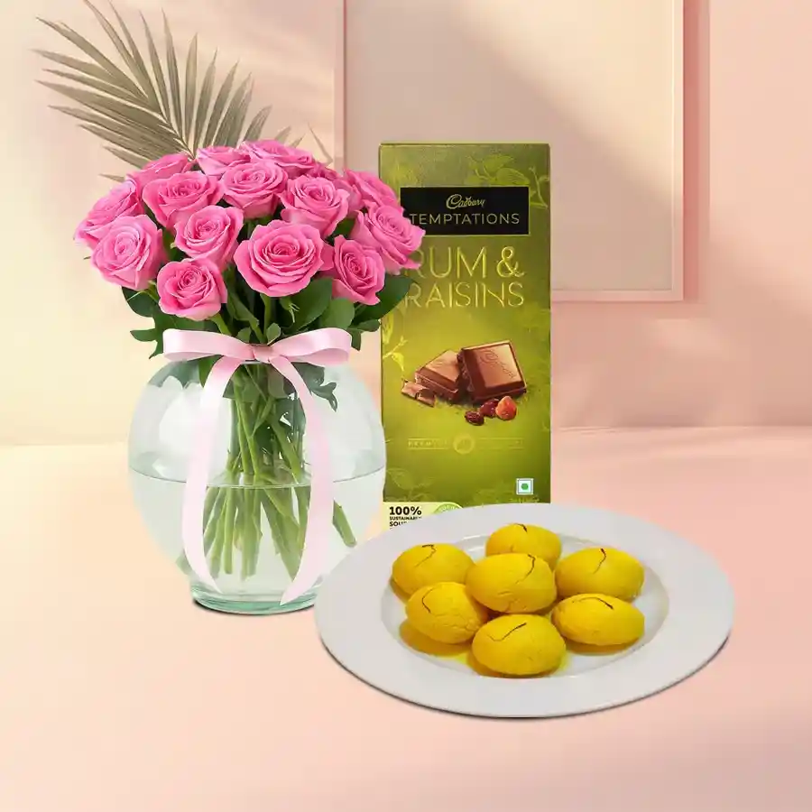 Elegant gift set featuring pink roses, Raj Bhog sweets, and Cadbury chocolate.
