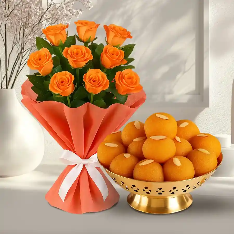 A vibrant bouquet of orange roses paired with Motichur Laddu in a delightful gift combo.