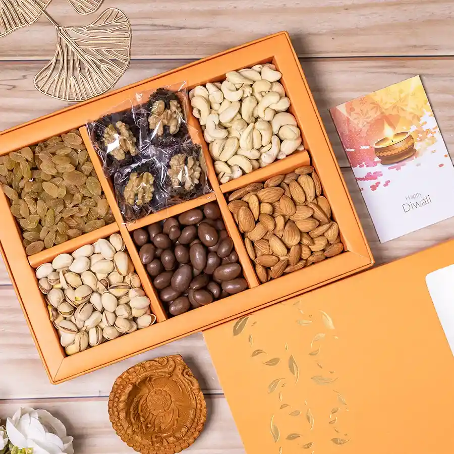 Festive Delight with Nutty Indulgence hamper featuring premium nuts, chocolate-coated almonds, walnut-stuffed dates, and a mud diya in a reusable gift box.