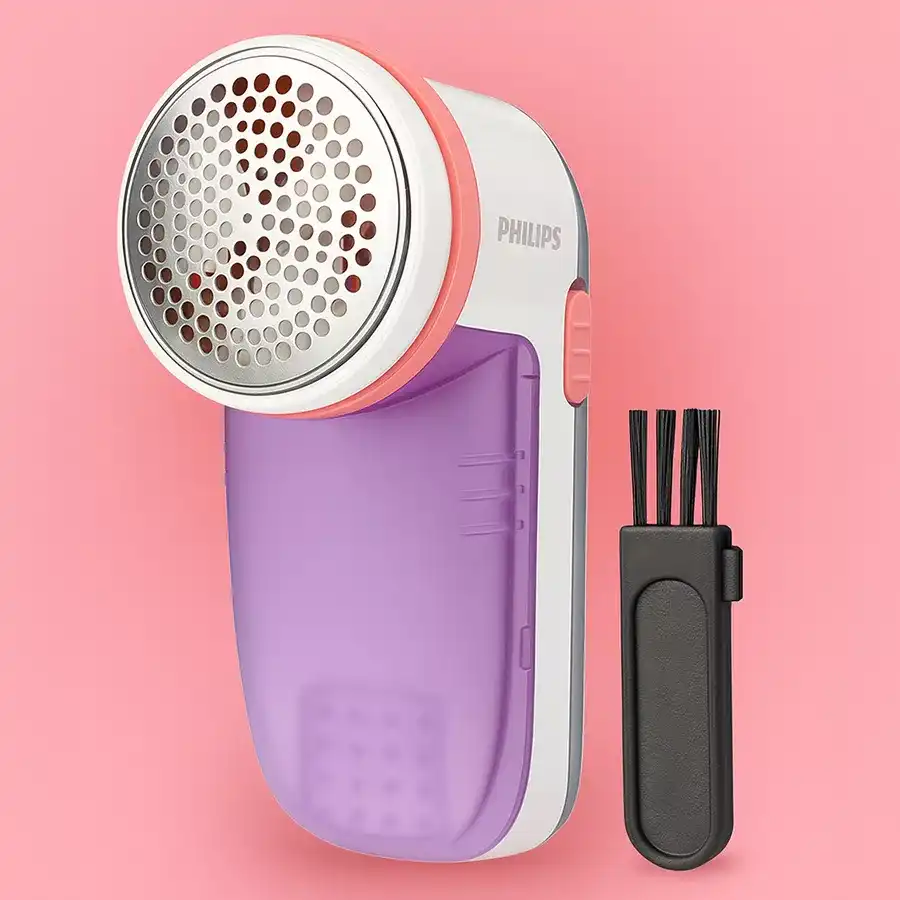 Philips Effortless Fabric Shaver in white with batteries and cleaning brush for removing lint and fabric pills.